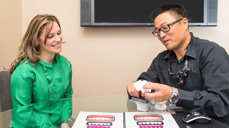 Dr. Chung showing a patient a model with porcelain veneers