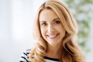 A woman smiling and showing the results of her smile makeover