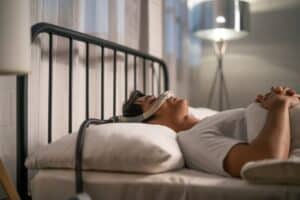 A man lying on his back wearing a CPAP machine