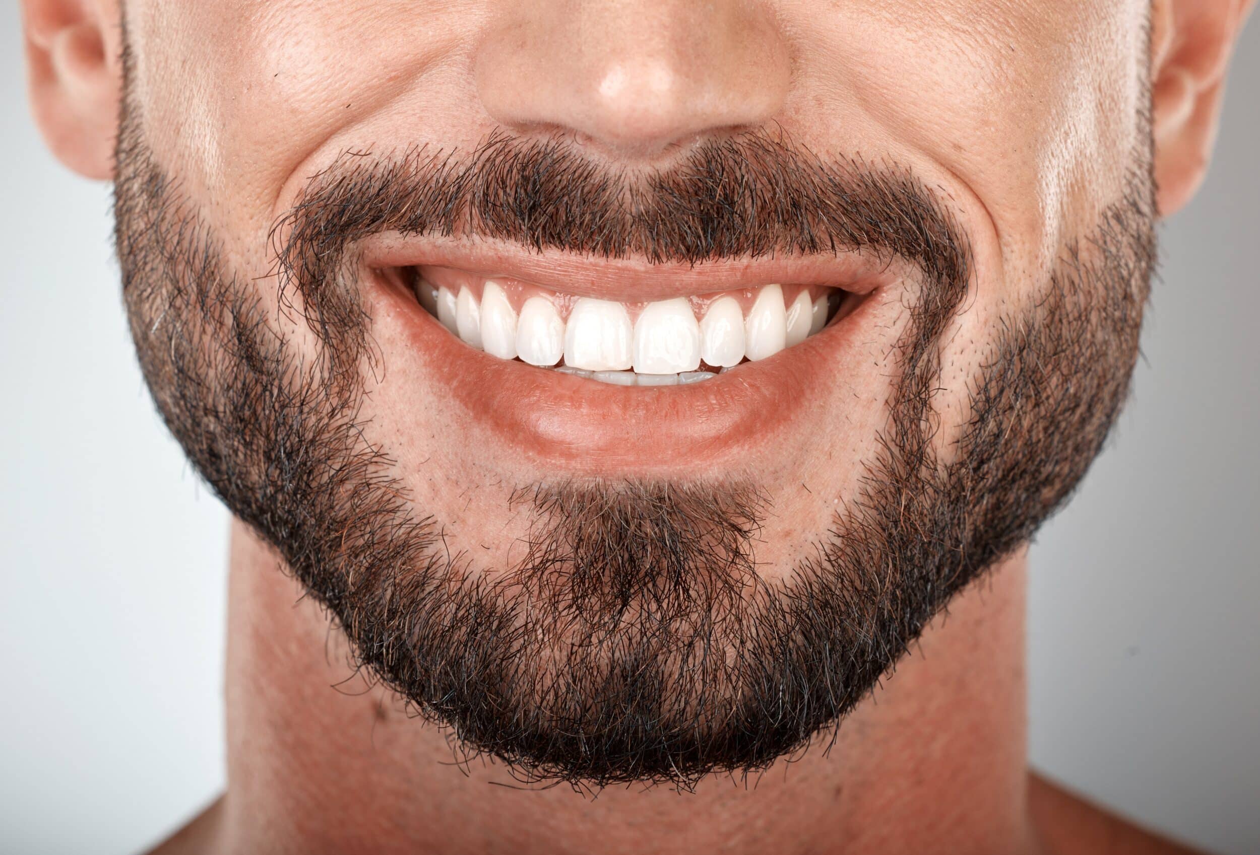A man smiling and showing the results of adult orthodontics in Oakton