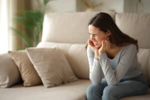 Woman experiencing TMJ jaw pain.